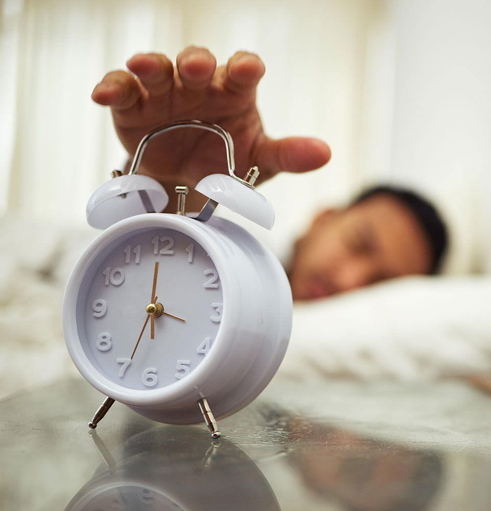 sleep problems man hitting alarm clock