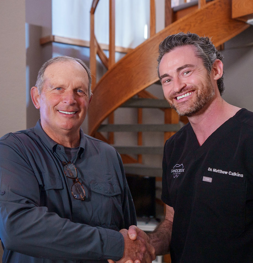 dr calkins with dental patient shaking hands